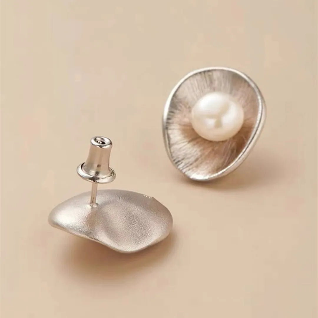 A pair of gold-coloured geometric sterling silver ear studs featuring a central pearl.