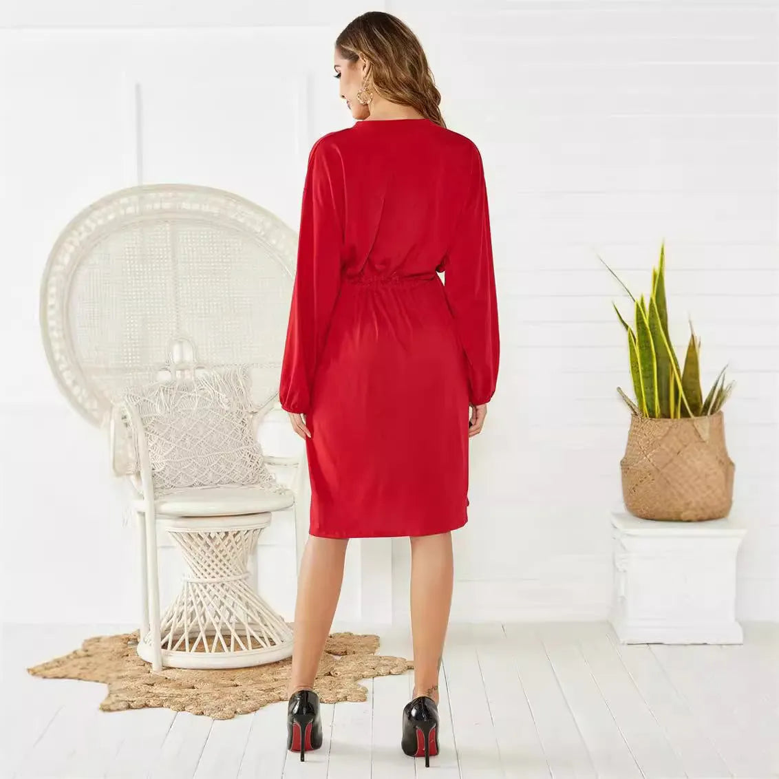 A women's black A-line midi dress with long sleeves, an elastic waist, and an included waist-cinching belt.