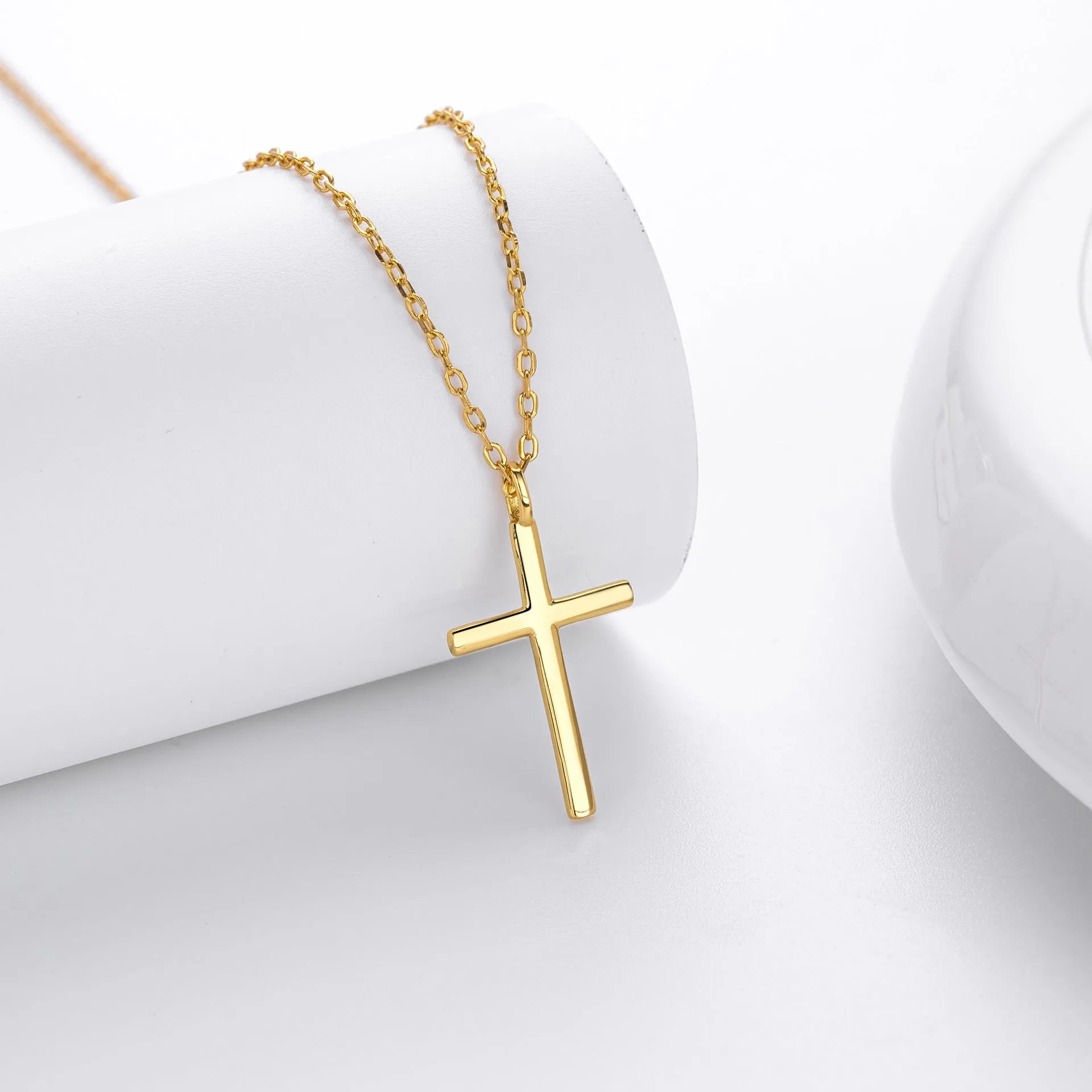 Simple glossy cross pendant on a sterling silver O-chain necklace, shown in gold, platinum, and rose gold finishes.