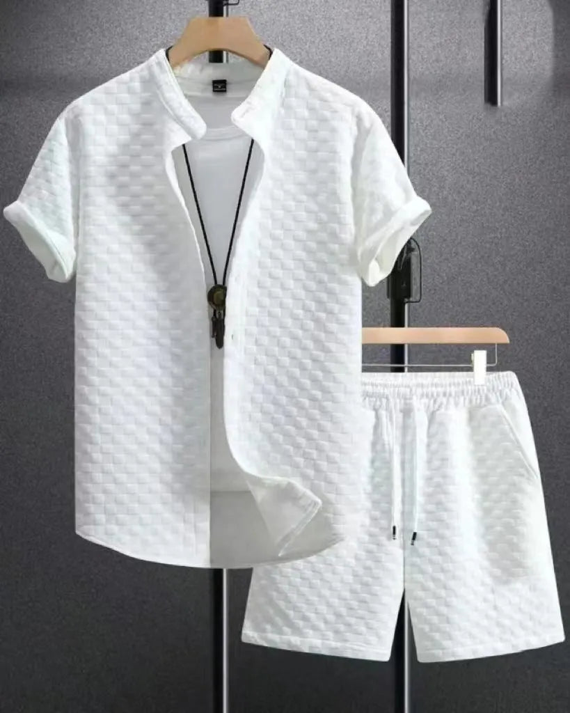 Man wearing a beige jacquard short sleeve suit jacket and matching shorts on a plain background.