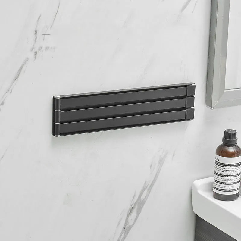 Nordic style folding towel rack in black mounted on bathroom wall with towels