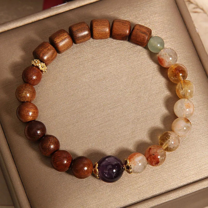 Yellow tower crystal, ebony, and amethyst bead bracelet with pearl and rhinestone details.