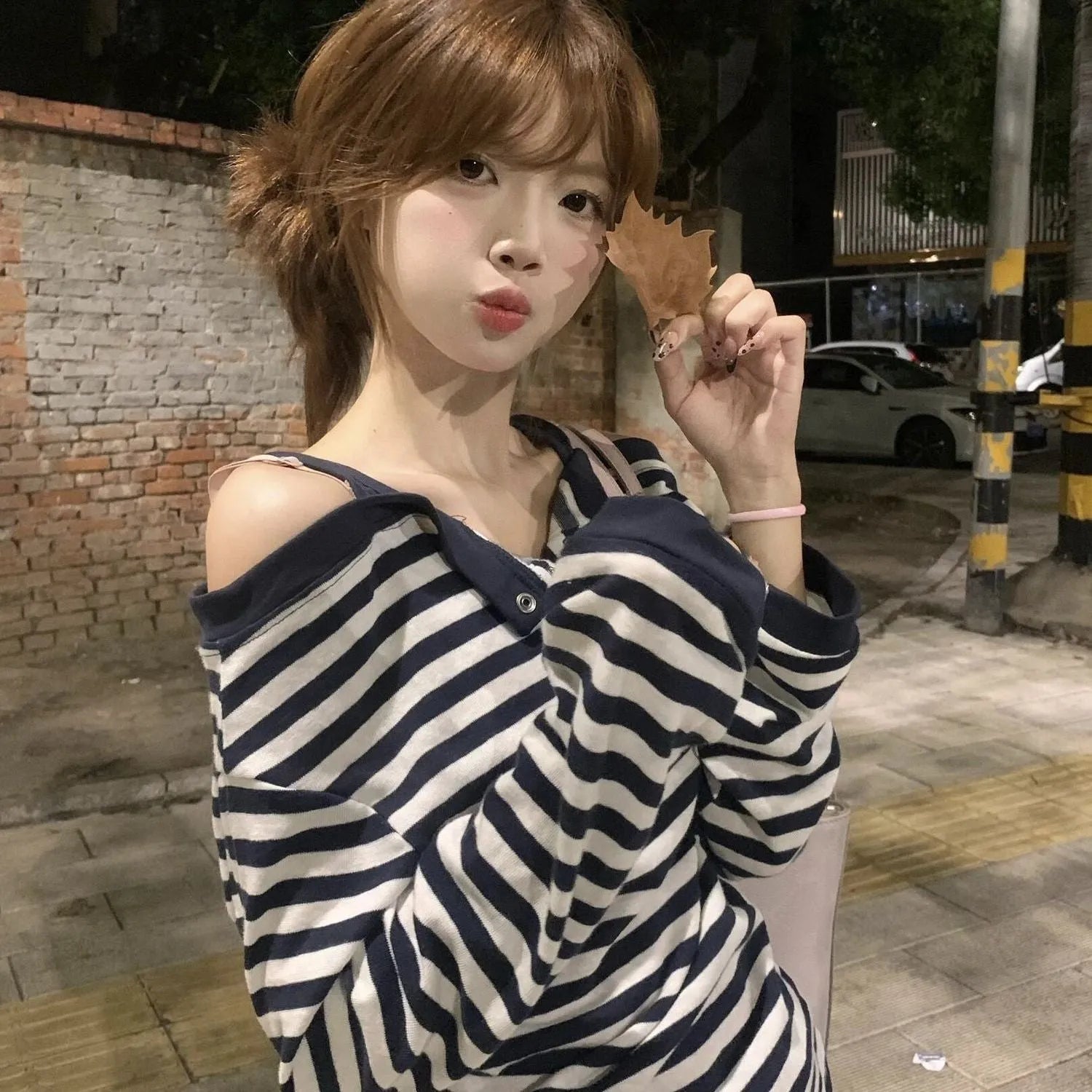 Dark blue Korean-style women's oversized long sleeve t-shirt with stripe and embroidery details on a hanger.