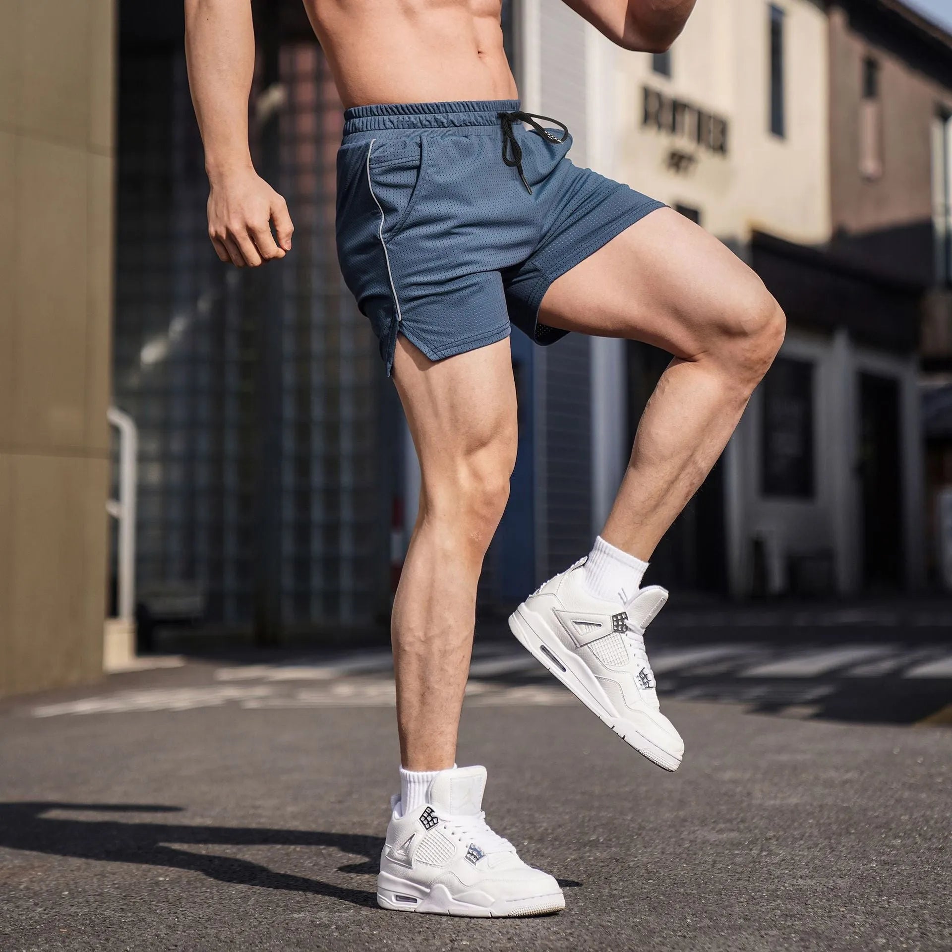 Men's black straight leg polyester sports shorts on a hanger