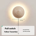 Vintage semicircle wall lamp with yellow cave stone shade and iron base, showing pull switch.