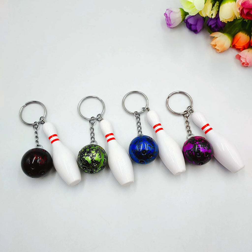 Miniature dark red bowling ball keychain on a metal ring with blue, purple, and green colour options shown