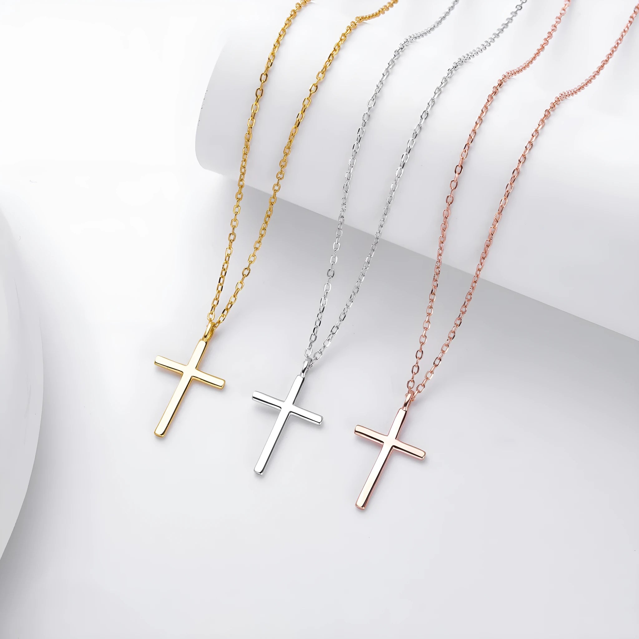 Simple glossy cross pendant on a sterling silver O-chain necklace, shown in gold, platinum, and rose gold finishes.