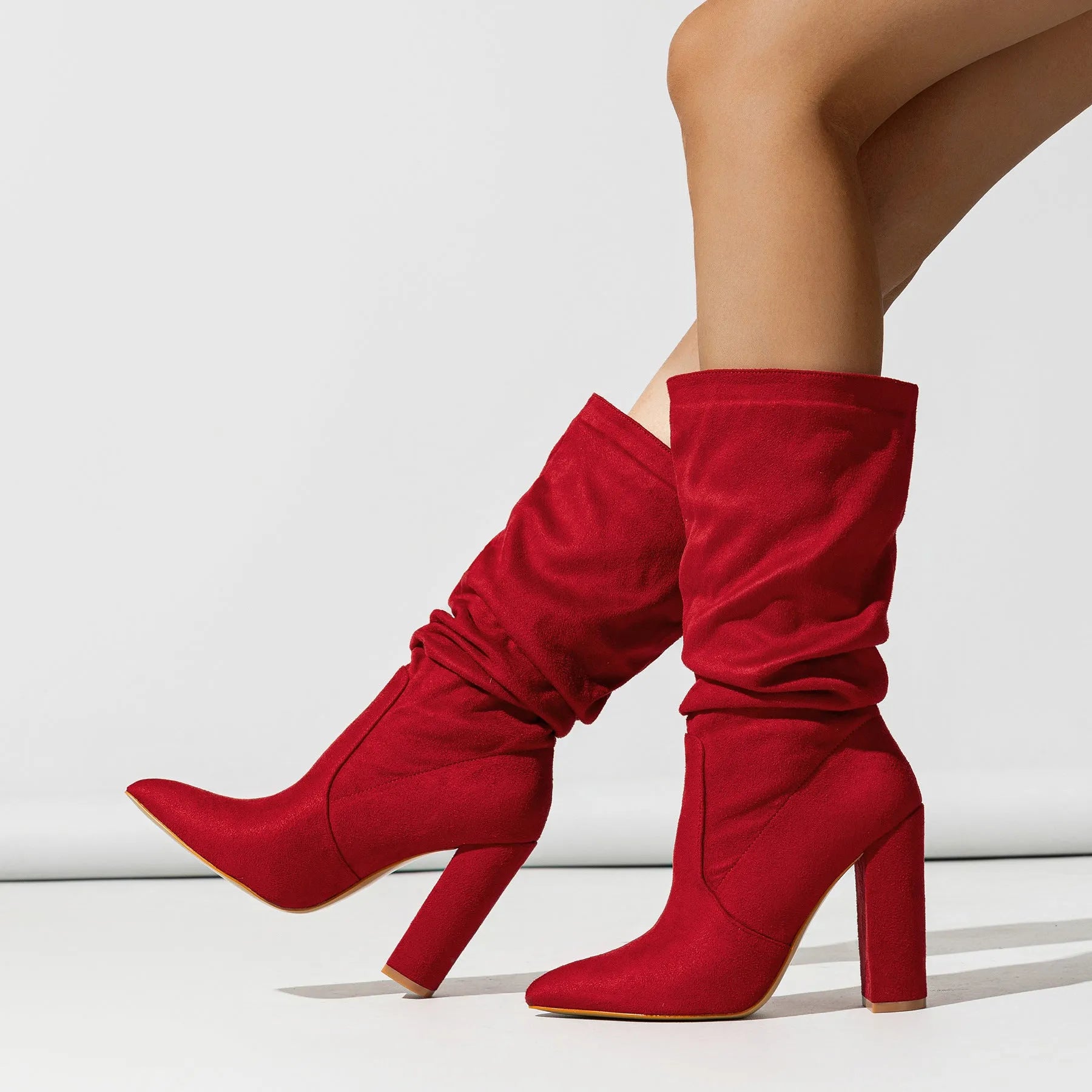 Women's black suede chunky high heel boots with pointed toe and oversleeve style.