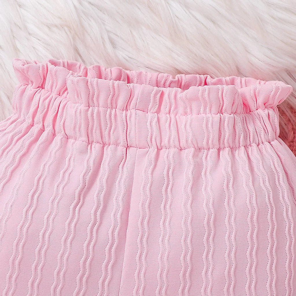 Pink baby girl three-piece set with ribbed frill long sleeve romper, pants, and matching headscarf on white background