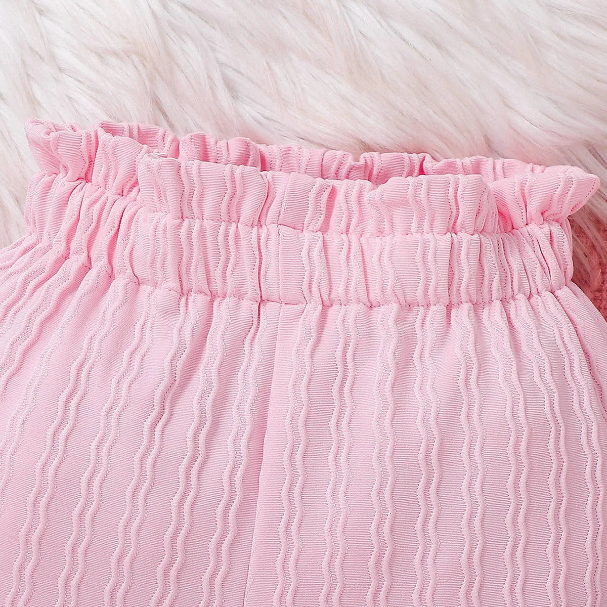 Pink baby girl three-piece set with ribbed frill long sleeve romper, pants, and matching headscarf on white background