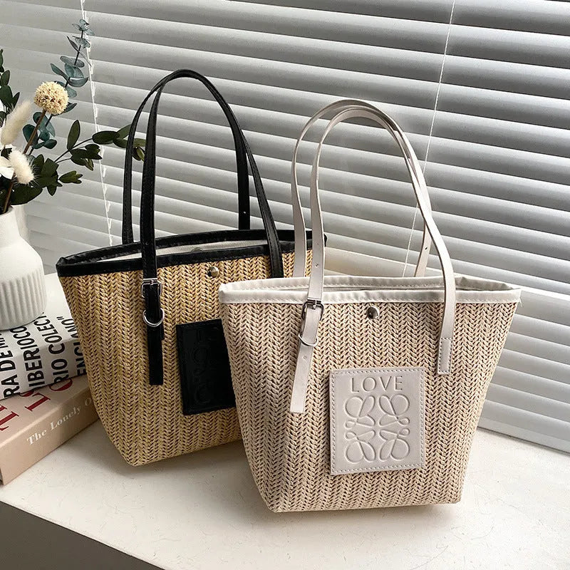 Straw woven women's shoulder bag in black with sewing thread detailing and three-dimensional pockets