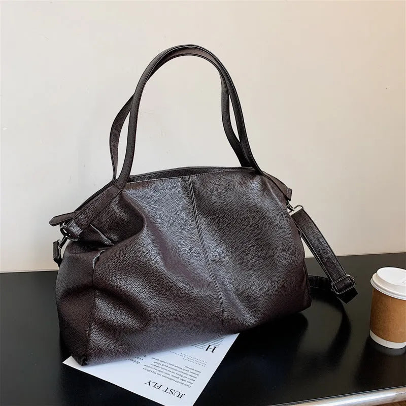 Large soft black PU messenger bag with car suture pattern, showing zip opening and adjustable shoulder strap.