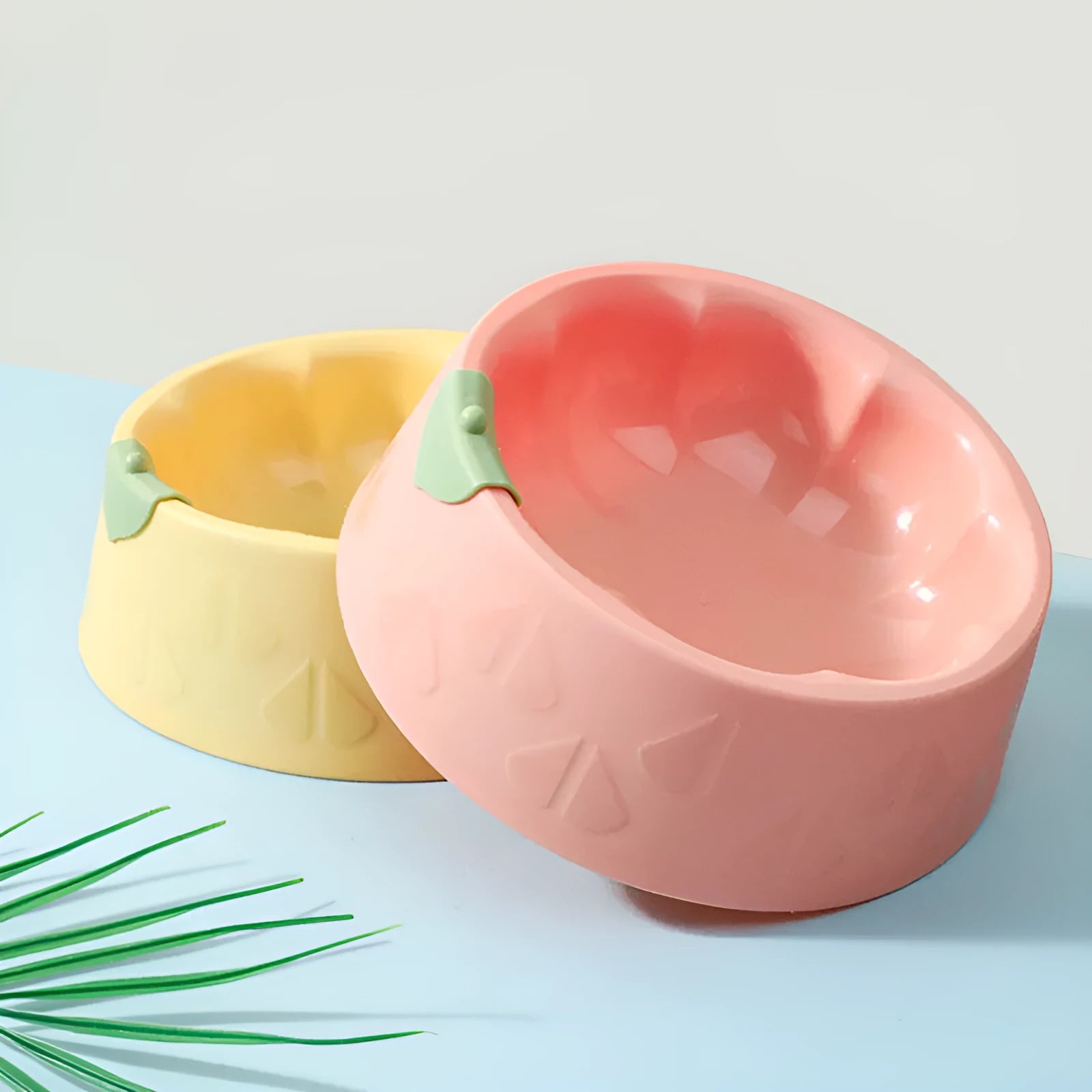 Green plastic pet double bowl with food and water compartments showing anti-tipping design