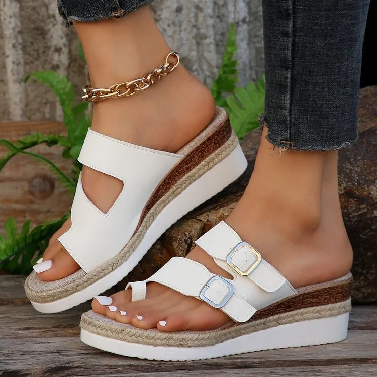 White women's wedge sandals with a woven patent leather upper, peep toe, and a finger-fit ankle strap on a rubber sole.