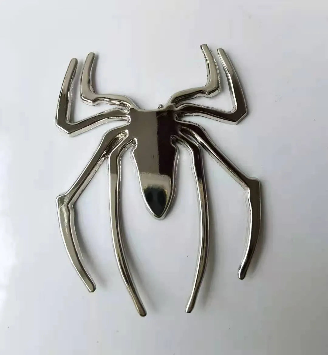 Three-dimensional metal spider bumper sticker in zinc alloy on a car bumper.
