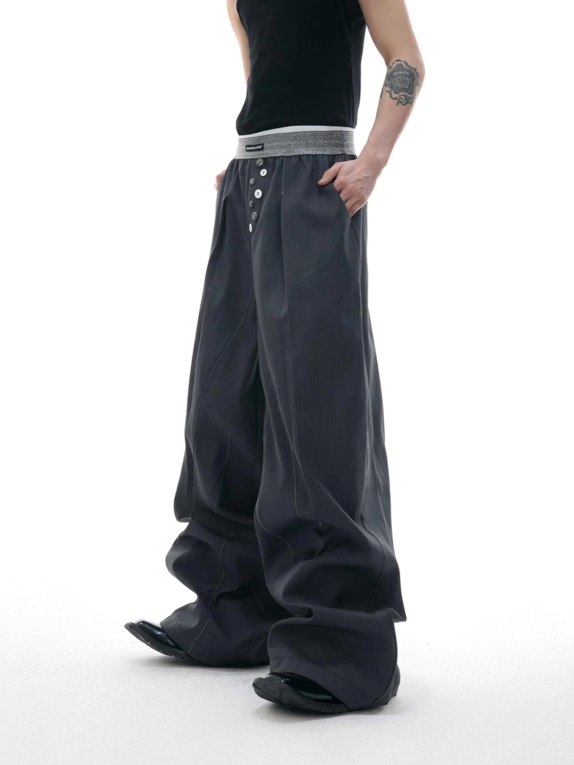 Drooping straight suit pants in black and grey colours showing high waist and button open line design detail.