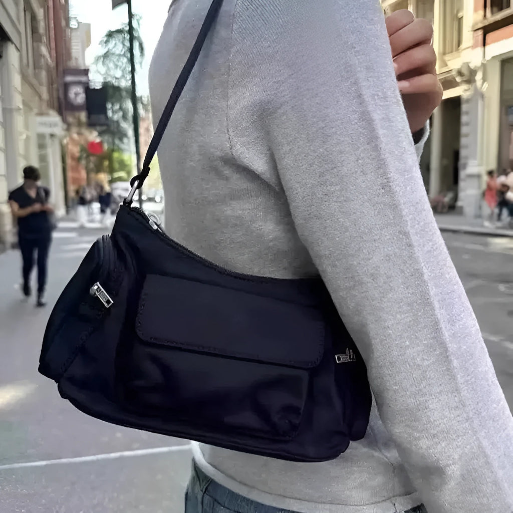 Black nylon shoulder bag with two pockets showing side line detail and 24cm dimensions