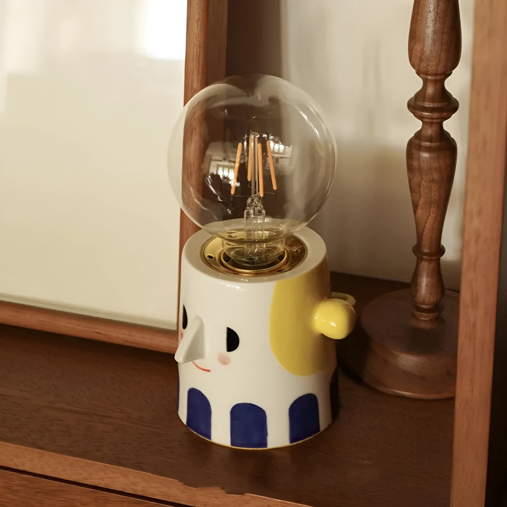 Handmade ceramic bedside lamp with ball headlight design on wooden surface