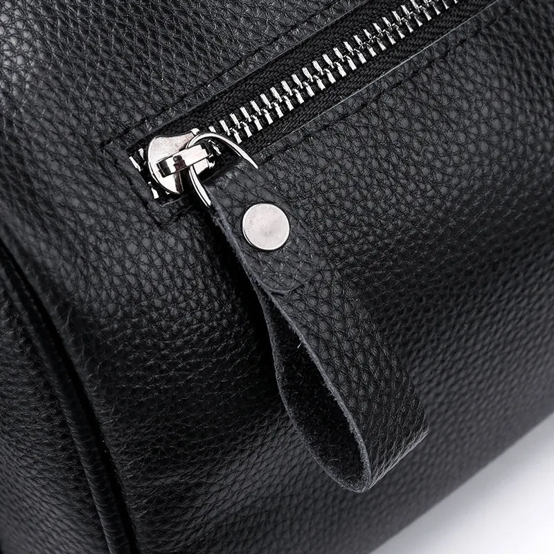 Black genuine leather one-shoulder crossbody bag showing its large size and crossbody strap.
