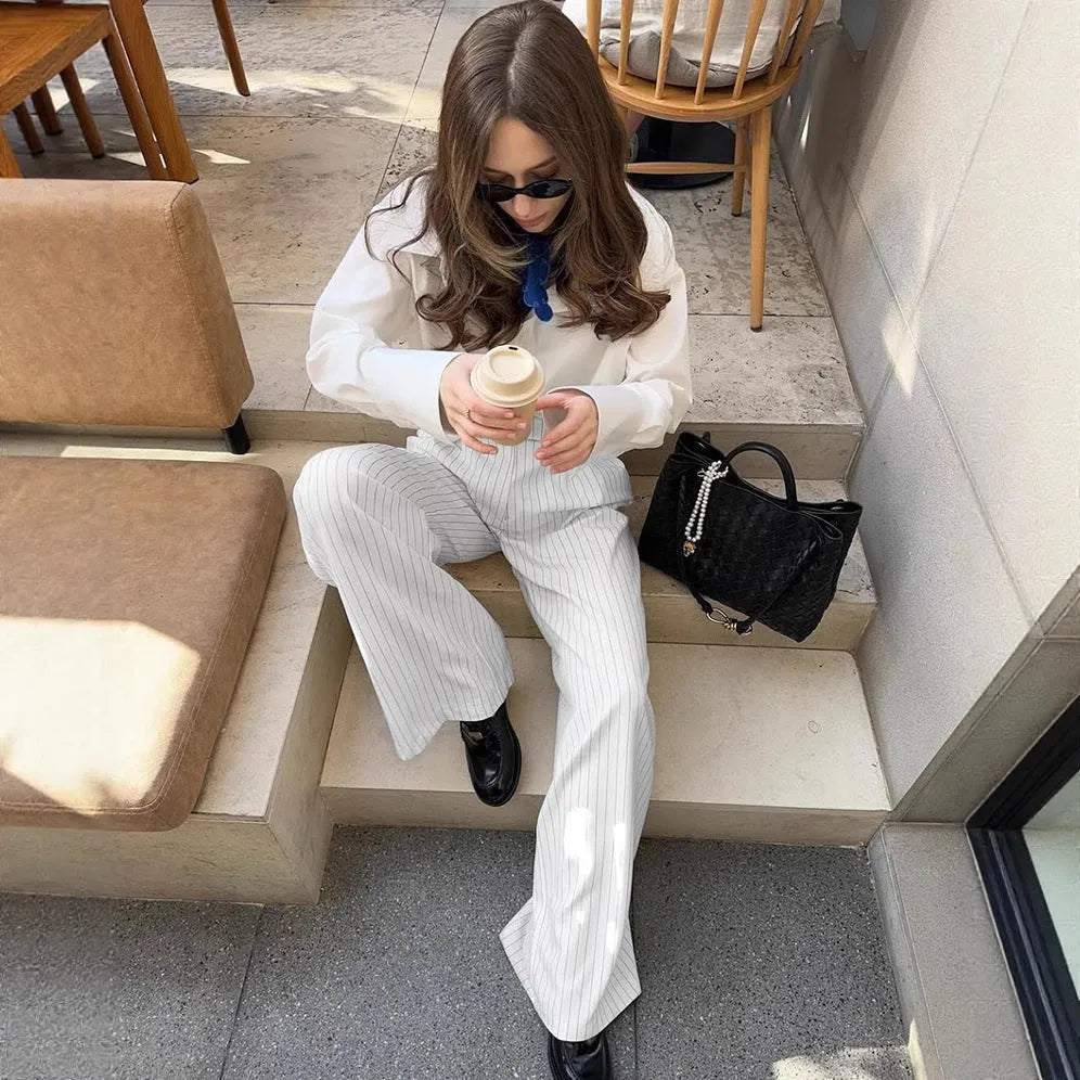 White striped wide-leg trousers with a front zip closure on a model.