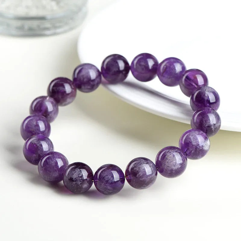 Natural Feather Amethyst Ruyi crystal bracelet with scattered geometry beads on a wrist.