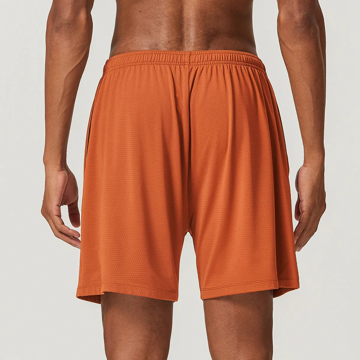 Man wearing sky blue double-layer quick-dry running shorts with a mid-waist fit.