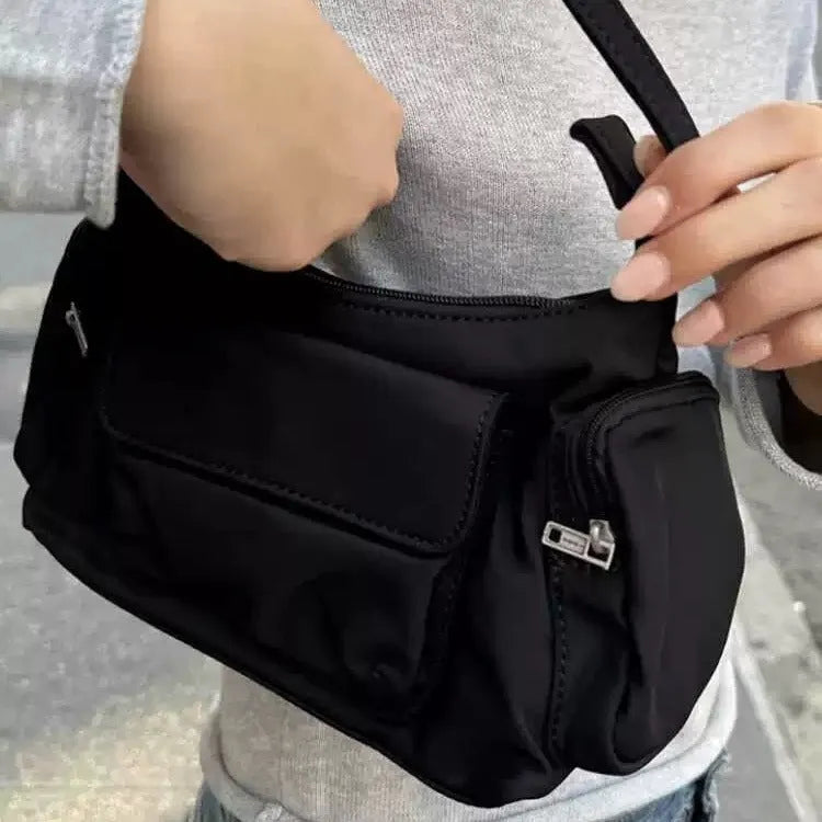 Black nylon shoulder bag with two pockets showing side line detail and 24cm dimensions