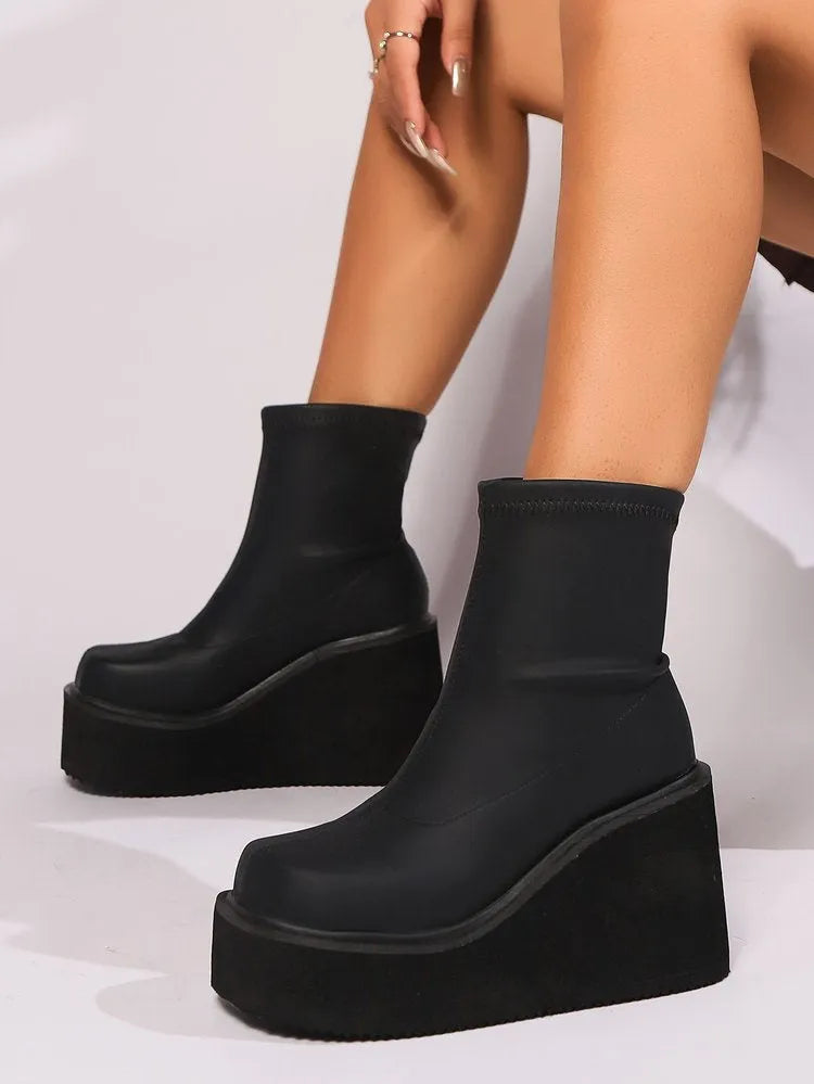 Plus size black women's boots with a wedge heel, round toe, and waterproof platform.