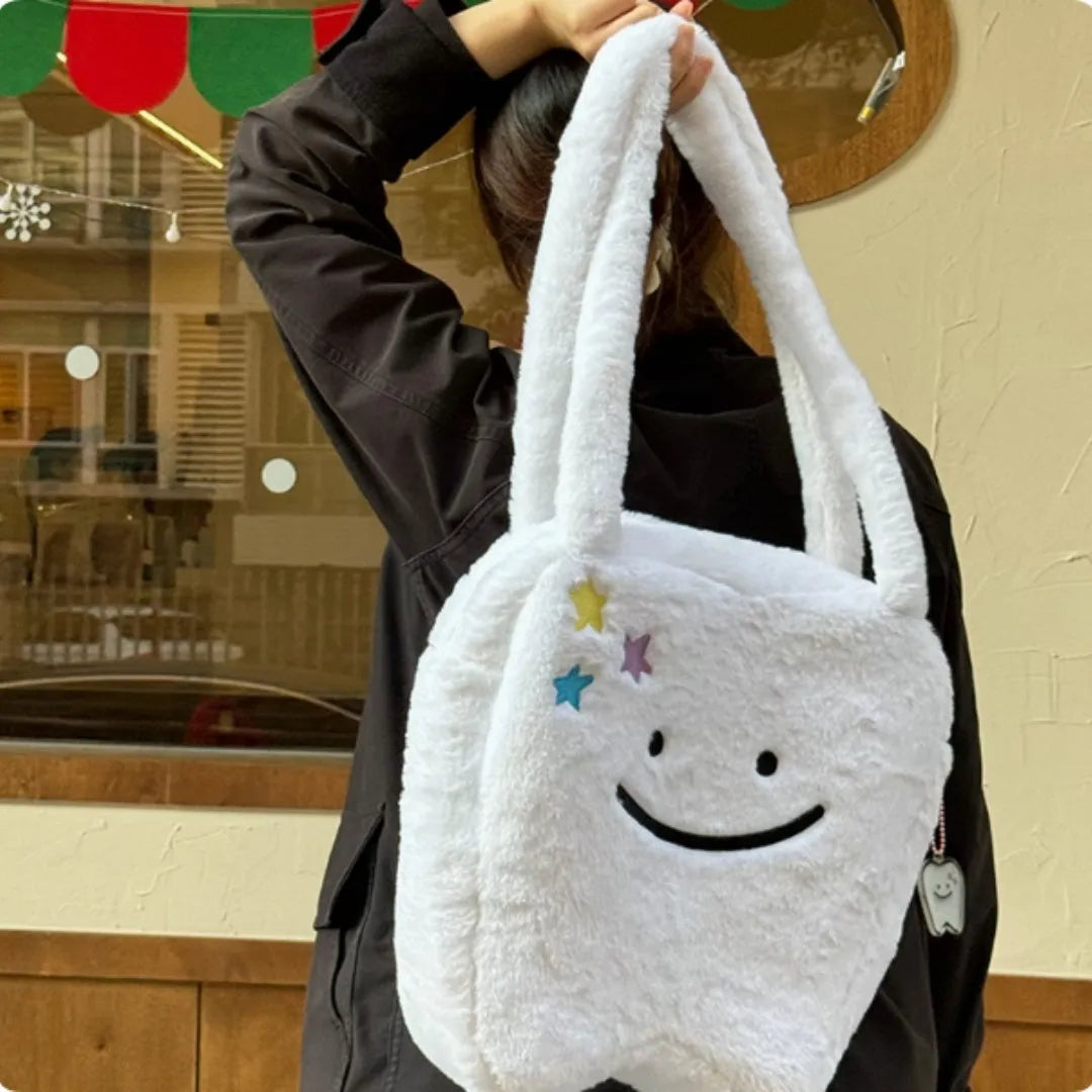 White plush large tooth design shoulder tote bag with zipper closure shown from the front.
