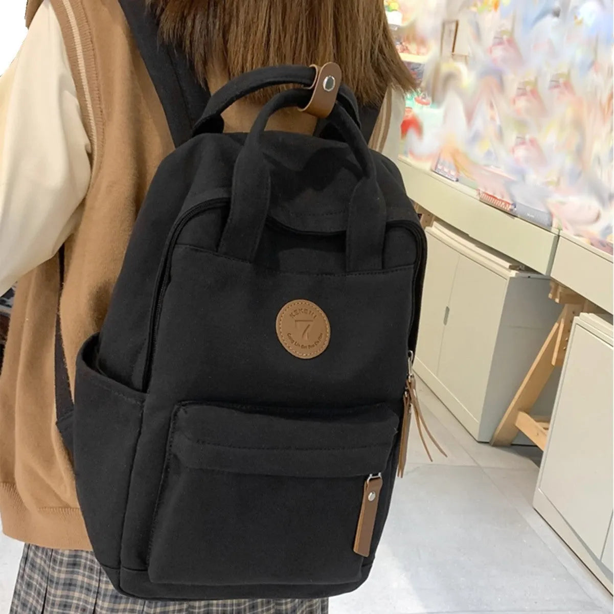 Black Oxford cloth fashion backpack with curved shoulder straps and retro sewing thread detailing
