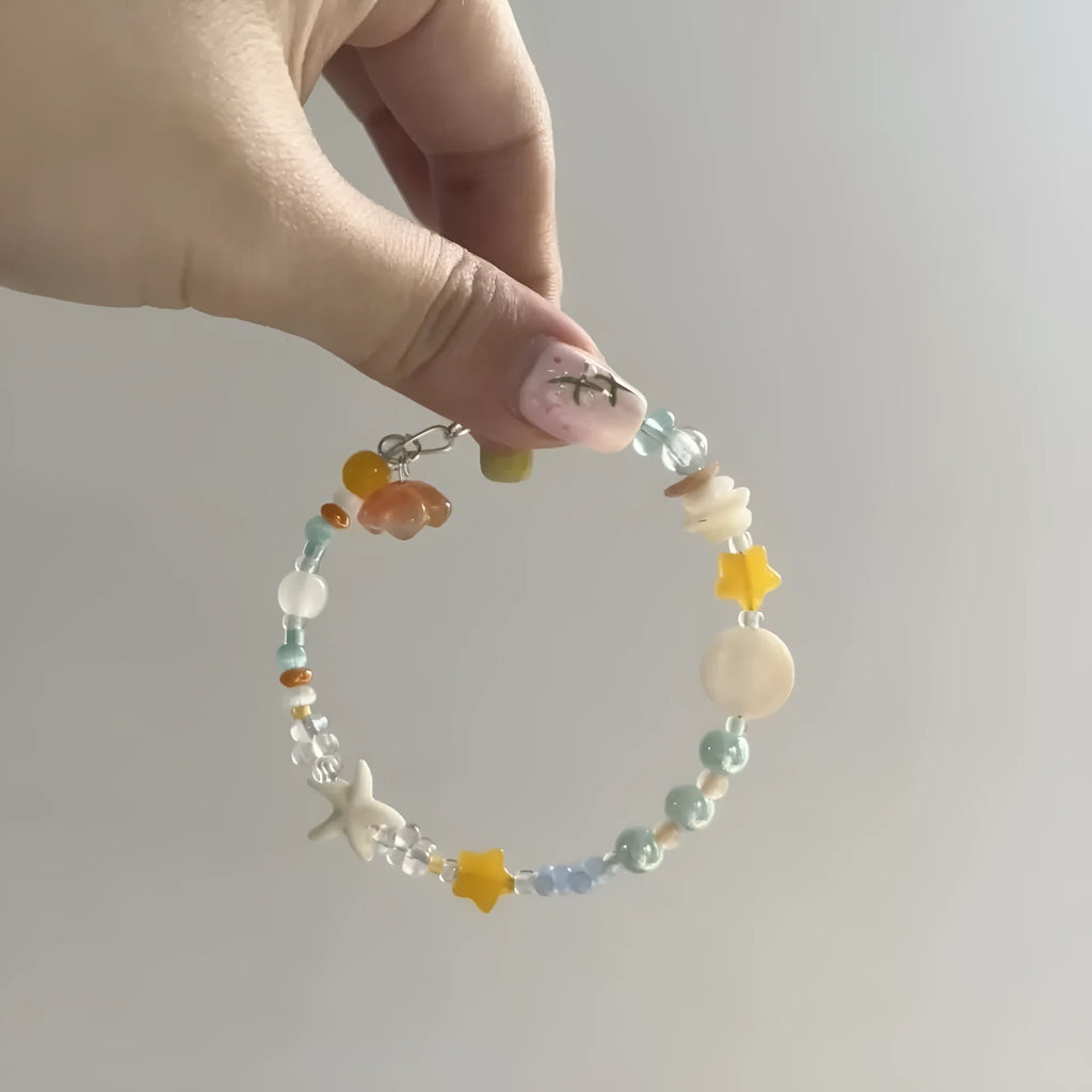 Orange alloy bracelet with diamond shape and round decorative elements on wrist