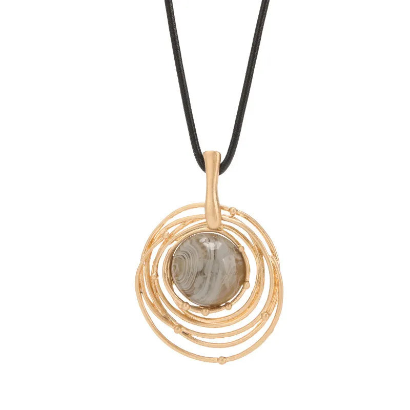 Large round gold geometric pendant on a long adjustable snakeskin rope chain necklace for sweaters