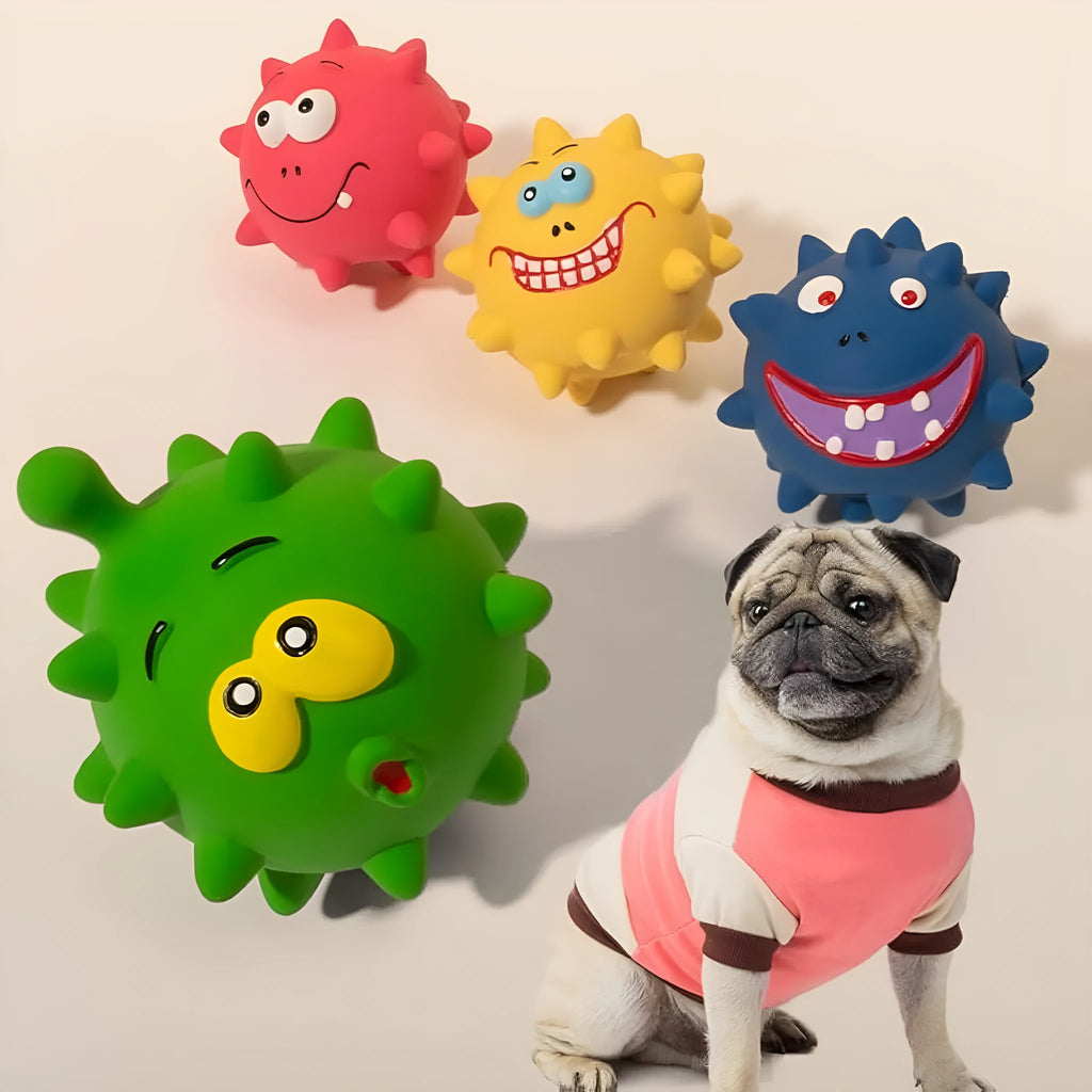 Set of four coloured squeaky dog balls with cute faces on a bumpy latex rubber surface.