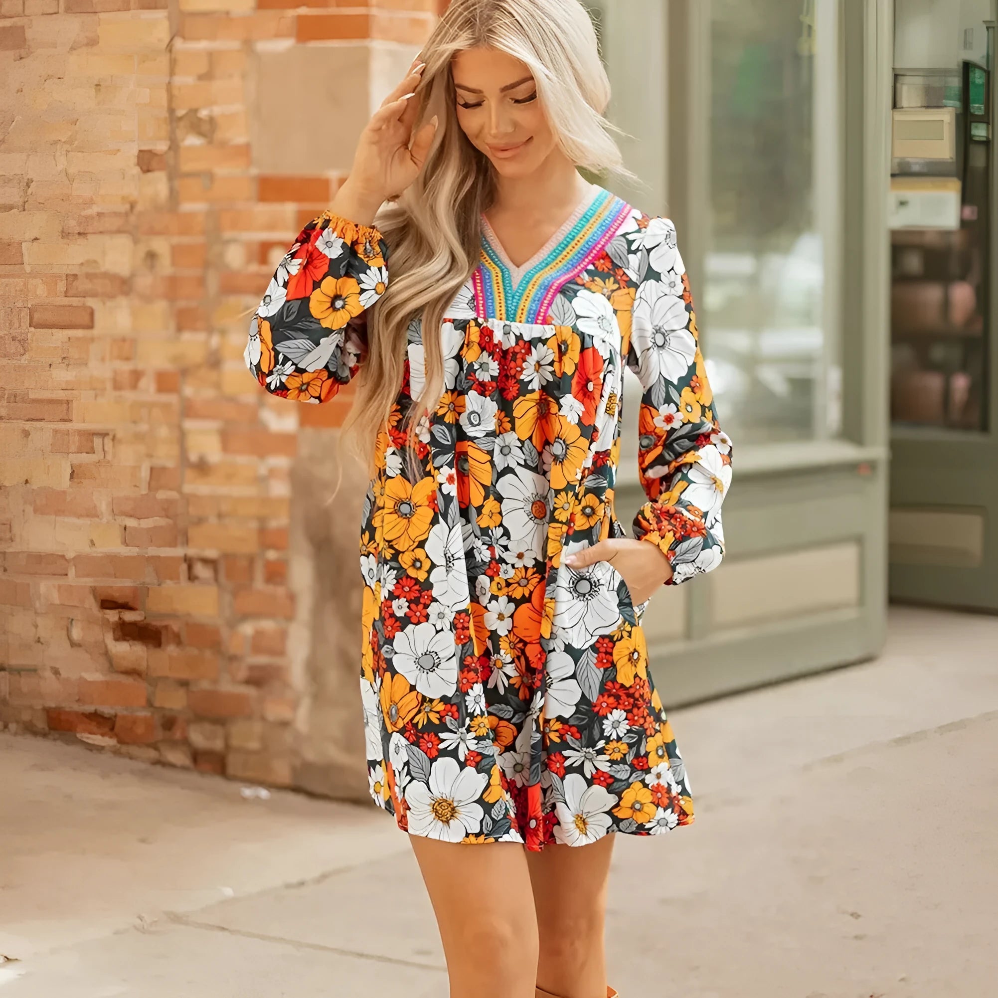 Orange floral print V-neck mini dress with long lace sleeves on a mannequin.