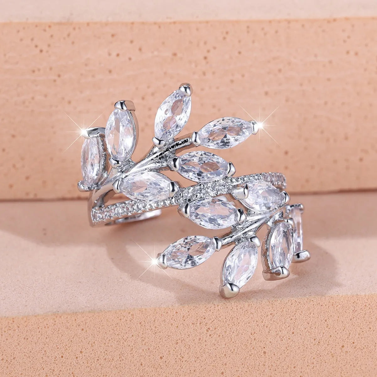 Adjustable copper leaf ring in platinum or rose gold finish on a white background