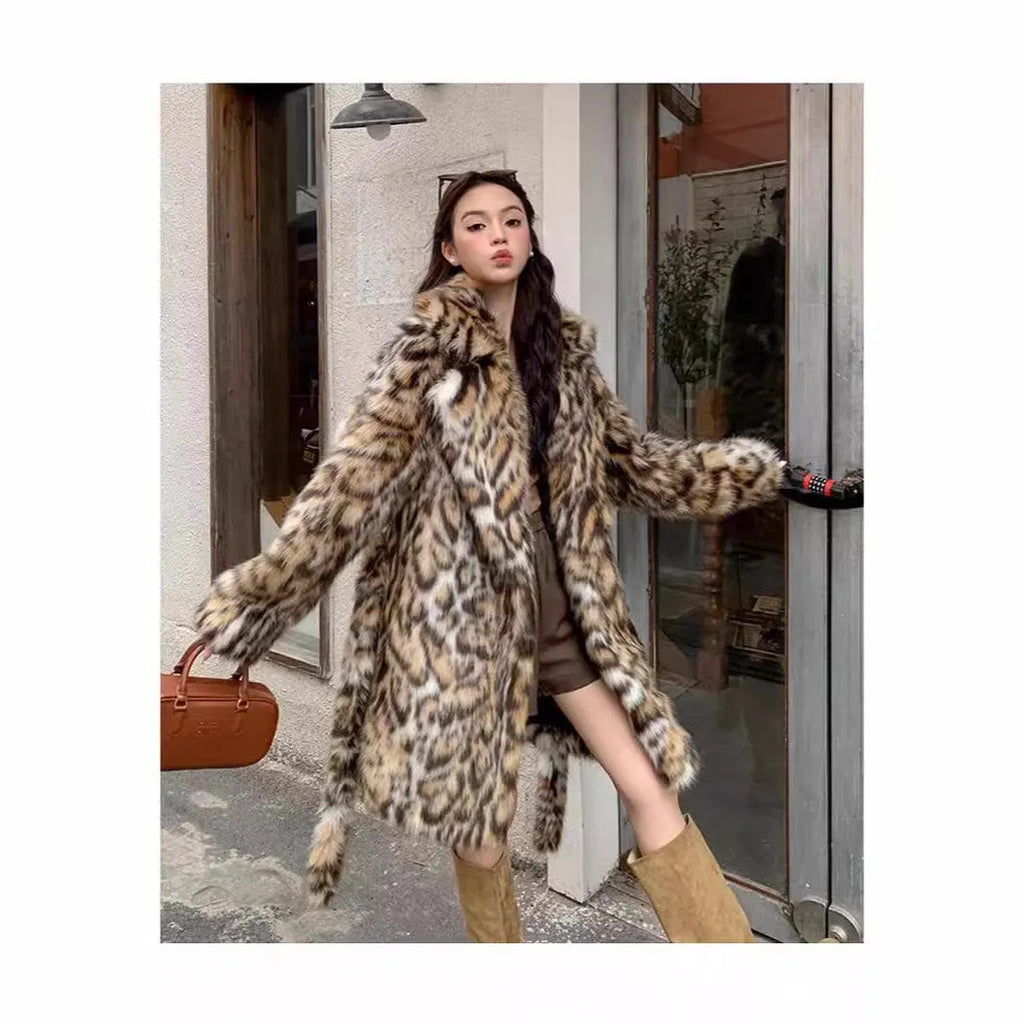A model wearing a black faux fur mid-length coat with a large fur collar and front pockets.