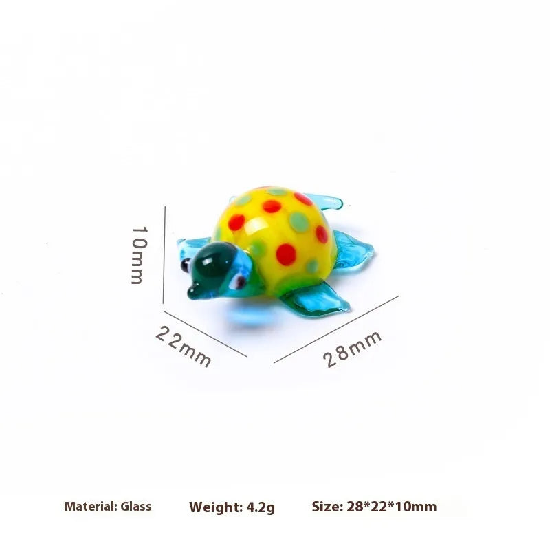 Geometric glass turtle ornament in a blue head and blue shell colour variant on a desktop.