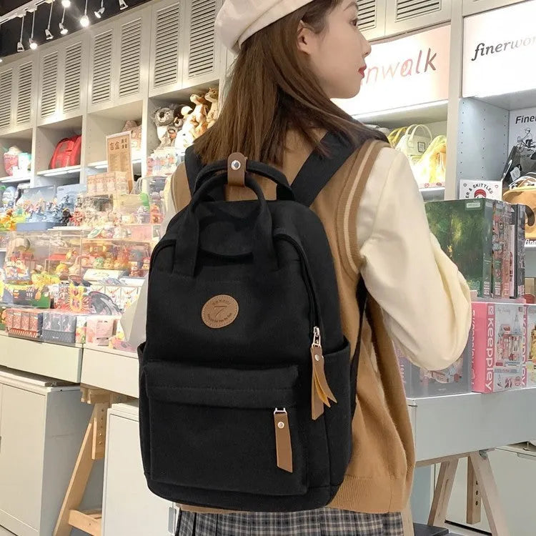 Black Oxford cloth fashion backpack with curved shoulder straps and retro sewing thread detailing