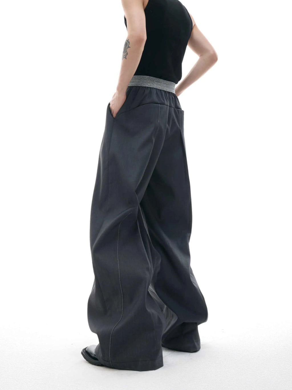 Drooping straight suit pants in black and grey colours showing high waist and button open line design detail.