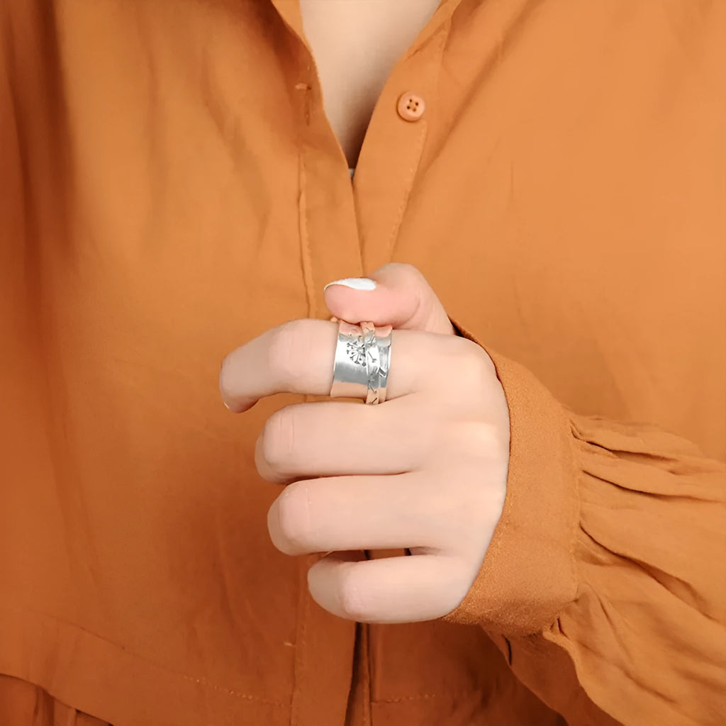 Silver rotatable flower ring on hand showing spinning floral design