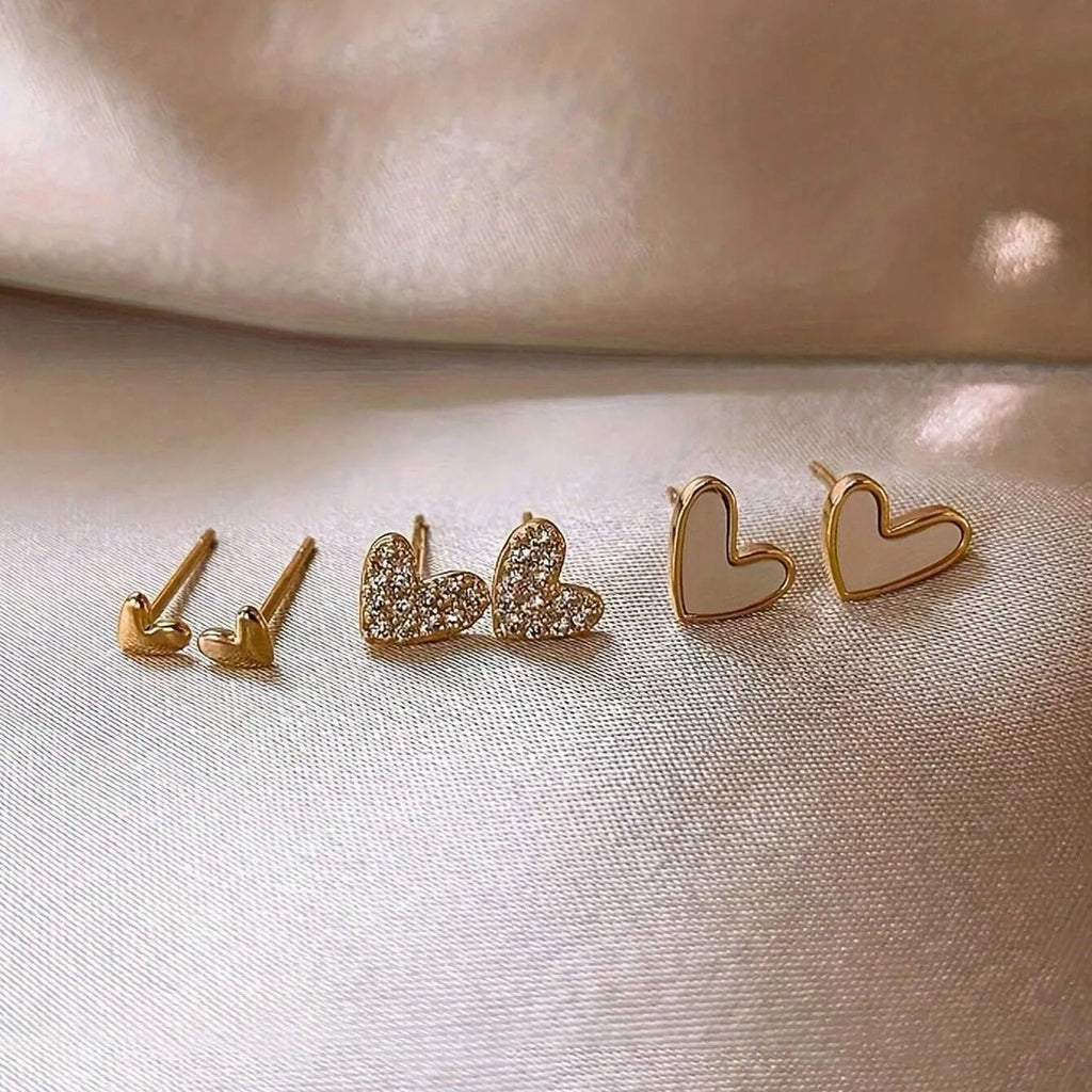 Three pairs of heart-shaped alloy earrings with electroplated finishes in gold, black, black-white, and pink colours