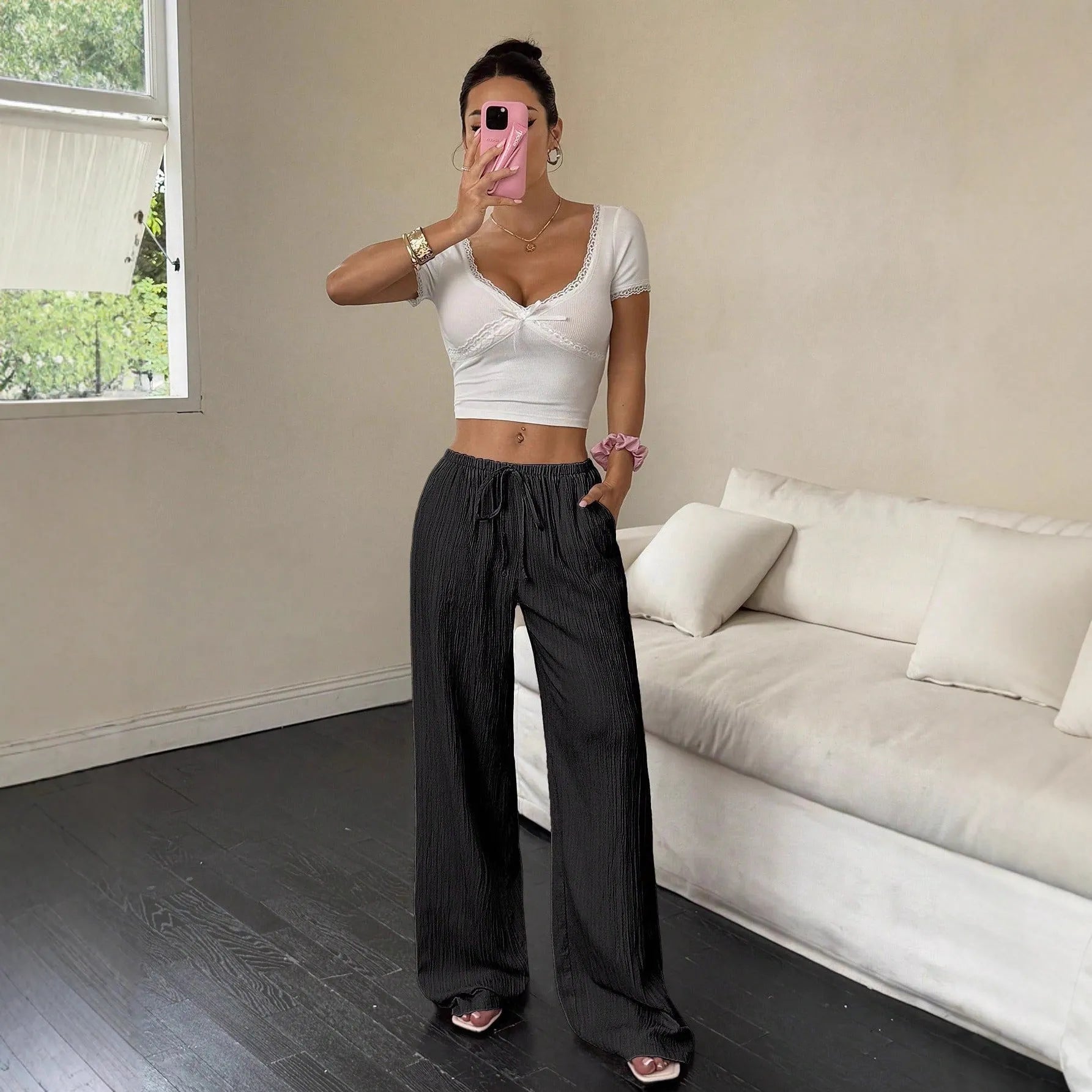 Women's black wide-leg trousers with lace-up waist detail and flowy silhouette