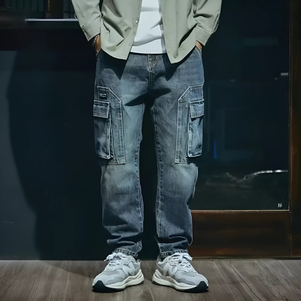Blue men's loose straight-leg jeans with a zip fly on a neutral background.