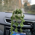 Green and white knitted wool car plant ornament with basin base and hanging rope.