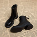 Women's black ankle boots with flat heel, back zipper, and round toe