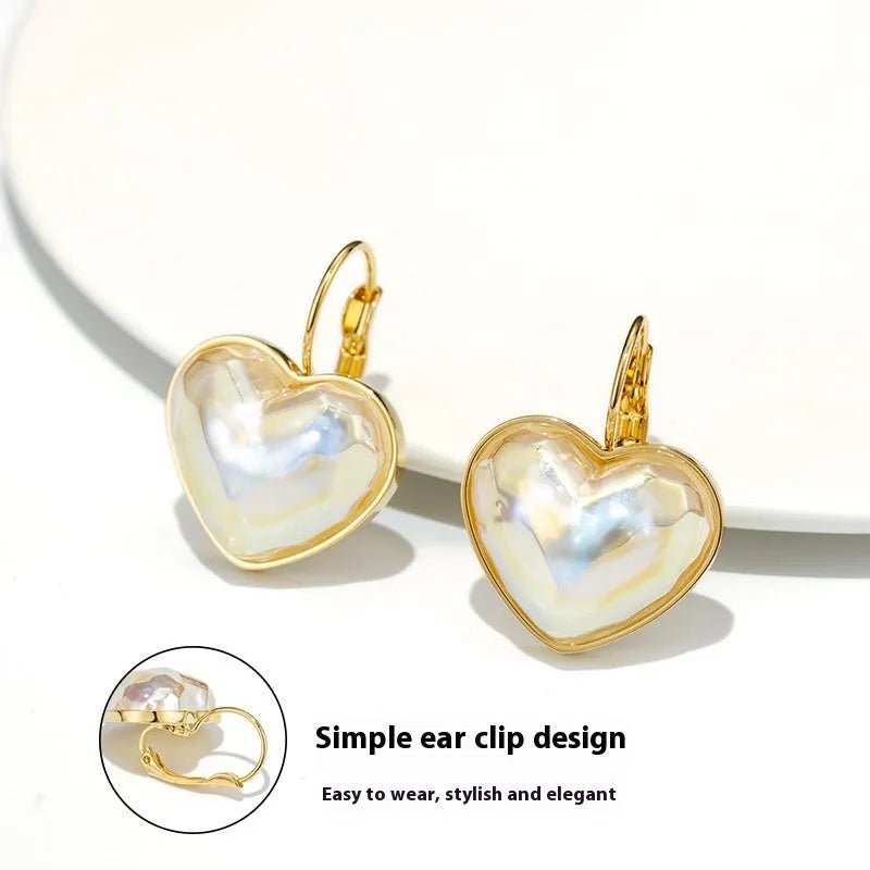 A pair of gold-coloured minimalist alloy ear clip earrings for women on a plain background.