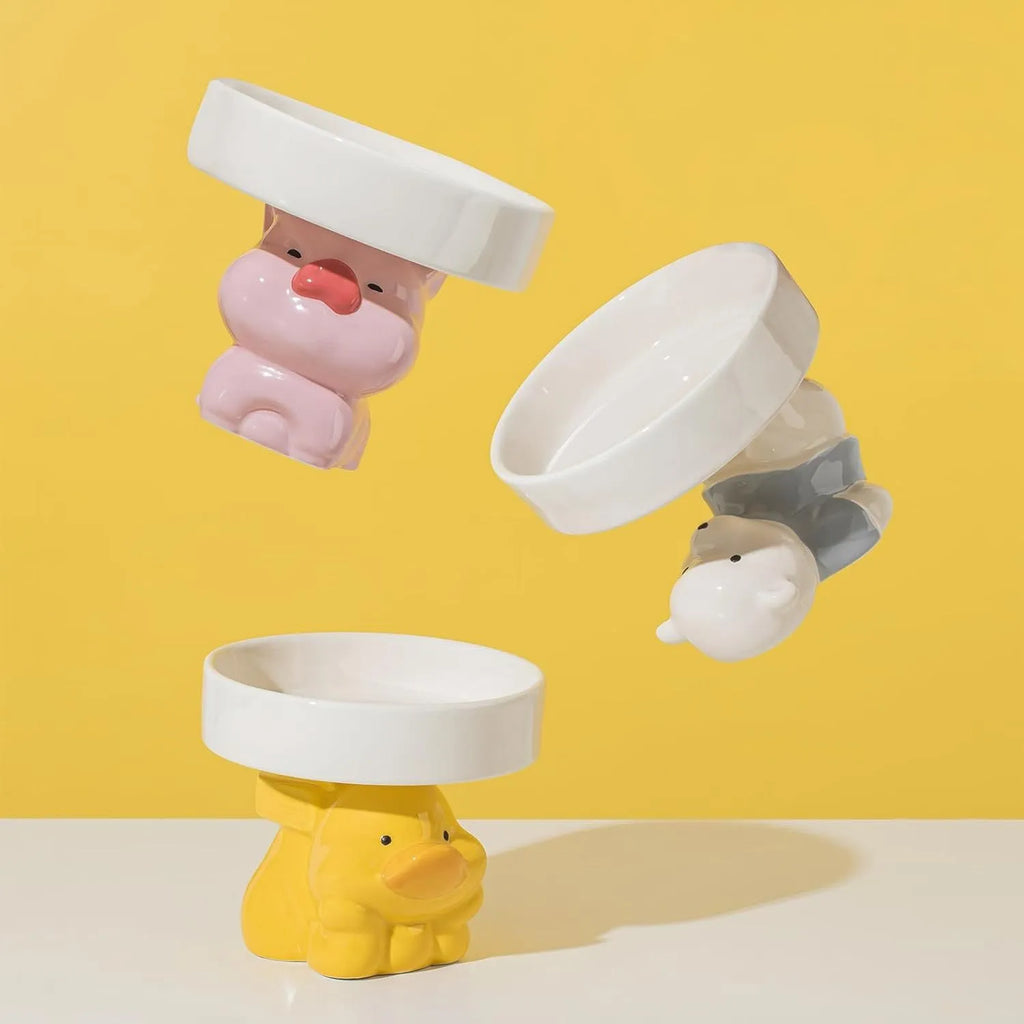 Raised ceramic cat bowl with animal theme design in pink, yellow, or white.