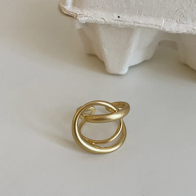 Gold and silver matte metal open rings with three-dimensional interlaced geometric design