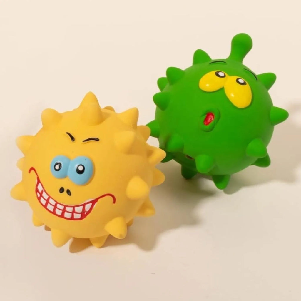 Set of four coloured squeaky dog balls with cute faces on a bumpy latex rubber surface.