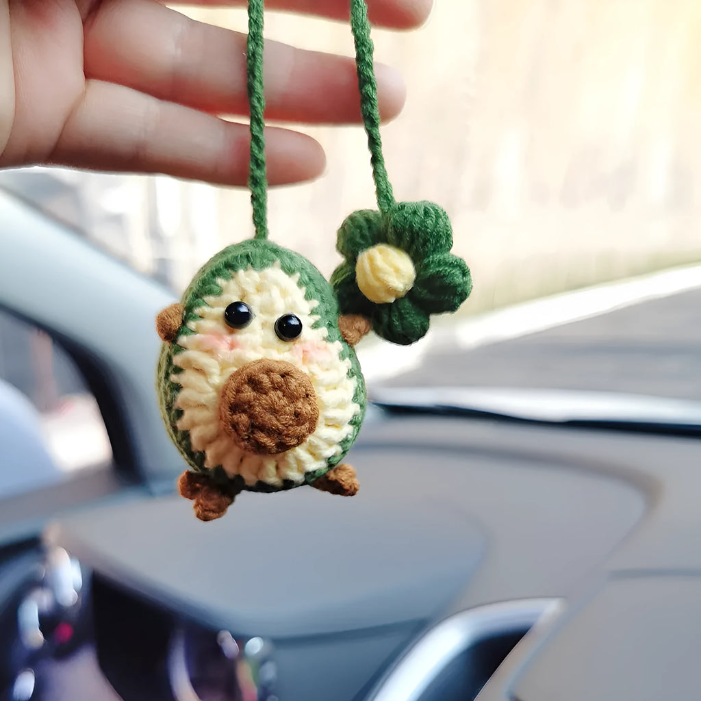 Handmade crocheted avocado-shaped and rainbow pattern car pendants made from wool yarn.